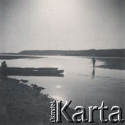 1930-1940, miejsce nieznane, Polska.
Krajobraz. Brzegiem jeziora spaceruje dziecko. Przy kajakach pozostałe osoby.
Fot. NN, kolekcja rodziny Walińskich, zbiory Fundacji Ośrodka KARTA