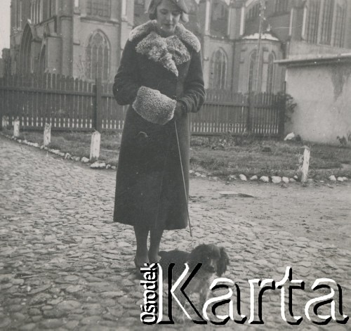 1930-1950, miejsce nieznane, Polska.
Dziewczyna z psem na spacerze. W tle kościół.
Fot. NN, kolekcja rodziny Walińskich, zbiory Fundacji Ośrodka KARTA