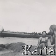 1930-1950, miejsce nieznane, Polska.
Nad jeziorem. Jedna osoba jest zakopana w piasku.
Fot. NN, kolekcja rodziny Walińskich, zbiory Fundacji Ośrodka KARTA