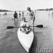 Lipiec 1958, Warszawa, Polska.
Warszawiacy na plaży nad Wisłą, mężczyzna z dwójką dzieci siedzi w kajaku z oznaczeniem PTTK.
Fot. Romuald Broniarek, zbiory Ośrodka KARTA