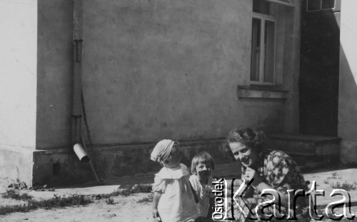 przed 1939, Ostróg nad Horyniem, Wołyń, Polska
Kobieta z dziećmi przed domem.
Fot. NN, zbiory Ośrodka KARTA, kolekcę Tadeusza Ignatowicza udostępniła Maria Różańska.

