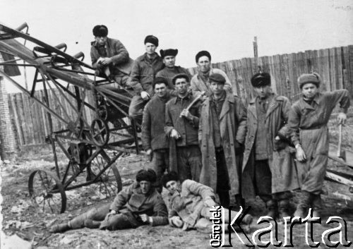 1955, Karaganda, Karagandyjska obł., Kazachska SRR, ZSRR.
Wolnoosiedleńcy oraz Ukraińcy deportowani w 1950 r. Grupa ludzi w strojach roboczych przy metalowej maszynie (szkielet taśmociągu?). W tle ogrodzenie.
Fot. NN, zbiory Ośrodka KARTA, udostępnił Bolesław Kratus