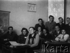 1943, Craiova, Rumunia
Klasa maturalna liceum, siedzą od lewej: Zuzanna Turasiewicz, Erna Mozes, Irena Wierzbanowska, Wanda Szporek-Dybkowska (w głębi), Irena Bernacka, profesor matematyki Piotr Szymański, Leontyna Tepel, stoją od lewej: Józef Gliński, Mikołaj Ślusak, Czesław Kordziński, Stanisław Drozd.
Fot. NN, zbiory Ośrodka KARTA, udostępniła Wanda Szporek-Dybkowska.