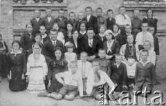 1931, Basów Kąt, powiat Równe, Wołyń, Polska
Personel i uczniowie szkoły powszechnej; z przodu pierwszy od lewej siedzi Tedeusz Walik, obok niego S. Krawczuk. W drugim rzędzie siedzą nauczyciele, od lewej: Jakub Głodek (zginął w Katyniu), żona kierownika szkoły, kierownik W. Romanowski (podczas wojny w 2 Korpusie gen. Andersa, po wojnie wrócił do Polski), spośród dzieci czworo to dzieci osadników wojskowych, pozostali to Ukraińcy.
Fot. NN, zbiory Ośrodka KARTA, udostępnił Tadeusz Walik.

