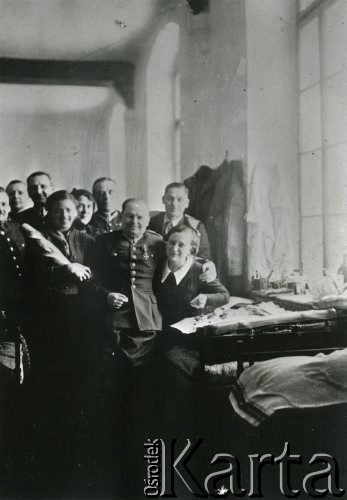 1940, Targu- Jiu, Rumunia.
Polscy wojskowi w obozie internowania; na zdjęciu kilku uśmiechniętych mężczyzn w mundurach i trzy kobiety.
Fot. NN, zbiory Ośrodka KARTA, udostępniła Barbara Tobijasiewicz.