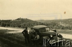 1940, Rumunia.
Polacy w Rumunii podczas II wojny światowej: Tadeusz Krajewski i dwaj mężczyźni NN przy samochodzie, w tle góry; na odwrocie pieczęć: