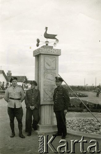 1940, Targu-Jiu, Rumunia.
 Obóz internowania żołnierzy Wojska Polskiego. Na pierwszym planie widoczny zegar słoneczny - kolumna, na której wyrzeźbiono symboliczne znaki, od dołu: służby uzbrojenia, marynarki wojennej, kwatermistrzostwa. Kolumna jest w górnej części zwieńczona rantem, na którym widnieją napisy 