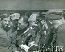 1940, Targu-Jiu, Rumunia.
 Obóz internowania żołnierzy Wojska Polskiego, przed barakiem stoi siedmiu oficerów w mundurach, rogatywkach polowych, rogatywkach garnizonowych i furażerkach na głowach. Trzeci od lewej kpt. pilot obserwator Tadeusz Krajewski. Na odwrocie pieczątka Oflag VI E 13 Geprüft.
 Fot. NN, zbiory Ośrodka Karta, album (A-XII), udostępnił A. Krajewski.
   
