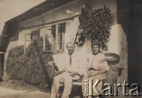 1933-1935, Czerniatyn, powiat Horodenka, woj. Stanisławów, Polska.
Wasyl Kosmenko z żoną przed chatą, na ścianie wiszą kolby kukurydzy.
Fot. NN, zbiory Ośrodka KARTA, kolekcję Edwarda Skrzyńskiego udostępniła Izabella Srzednicka