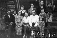 1941, Krutyj Klucz, Irkucka obł., ZSRR.
Polscy zesłańcy na Syberii. Grupa ludzi i pies na ławce przed chałupą z bali. Pierwszy od lewej: Michał Niedużak, obok jego żona Anna, za ich plecami starsza córka Janina, obok niej młodsza Stanisława, stoi z tyłu Józef Pułkowski, w białej koszuli Maria Kuźmierczak z d. Pułkowska.
Fot. NN, zbiory Ośrodka KARTA, udostępniła Maria Kuźmierczak