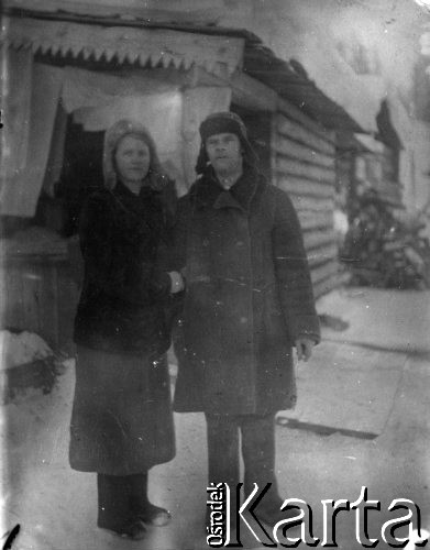 1944, Nowaja Jeruda, Krasnojarski Kraj, ZSRR.
Naczelnik nadzorujący Polaków deportowanych do Nowej Jerudy i pracujących przy wyrębie tajgi, na zdjęciu wraz z żoną przed swoim barakiem, w głębi widoczny barak rodziny Anny Sacały. Fotografia została podarowana Polakom przed ich wyjazdem do Jenisejska na punkt zbiorczy. Podpis na odwrocie: 