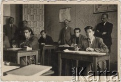 1942, Craiova, Rumunia.
Polscy uchodźcy w Rumunii podczas II wojny światowej. Matura z języka obcego w Polskiej Szkole w Craiovej. Uczniowie od lewej: Henryk Berlech, T. Zacharasiewicz, Jurek Kulczycki, Janek Gelbart; pod ścianą stoją dyrektorzy: Zdrojewski i Matkowski.
Fot. NN, zbiory Ośrodka KARTA, udostępnił Tadeusz Gaydamowicz.
