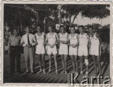 1943, Craiova, Rumunia.
Polscy uchodźcy w Rumunii podczas II wojny światowej. Drużyna siatkarzy Domu Polskiego w strojach YMCA. Od lewej: trener [Ślązak] pan Cichy, dyrektor Domu Polskiego Jerzy Sittauer-Bonkowicz, N. Liebling, A. Woyzbun, T. Zacharasiewicz, Z. Michalczyk, Z. Bieniek, R. Gondek.
Fot. NN, zbiory Ośrodka KARTA, udostępnił Tadeusz Gaydamowicz.