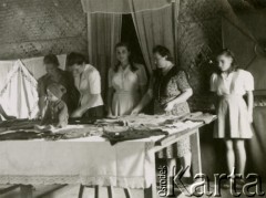 1942, Teheran, Iran.
Szwalnia w obozie dla Polaków ewakuowanych z ZSRR. [Polscy uchodźcy trafili do Iranu w 1942 wraz z nowoutworzonym Wojskiem Polskim pod dowództwem generała Władysława Andersa (w dwóch rzutach ewakuacyjnych z ZSRR w marcu i sierpniu). W sumie oprócz wojska dotarło tam 38 tysięcy Polaków, z czego ponad połowę stanowiły dzieci i młodzież. W Teheranie powstały trzy obozy dla ludności cywilnej i sierociniec; stąd kierowano Polaków do stałych osiedli w różnych rejonach świata (np. w Nowej Zelandii, Ugandzie, Meksyku)].
Fot. NN, zbiory Ośrodka KARTA, kolekcja Adeli Duszy przekazała Halina Guść