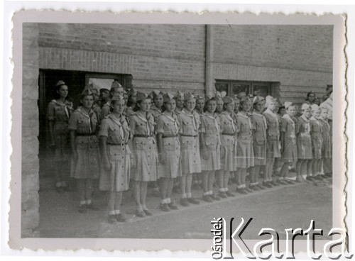 1943, Teheran, Iran.
Harcerki z obozu dla Polaków ewakuowanych z ZSRR (nr 2). [Polscy uchodźcy trafili do Iranu w 1942 wraz z nowoutworzonym Wojskiem Polskim pod dowództwem generała Władysława Andersa (w dwóch rzutach ewakuacyjnych z ZSRR w marcu i sierpniu). W sumie oprócz wojska dotarło tam 38 tysięcy Polaków, z czego ponad połowę stanowiły dzieci i młodzież. W Teheranie powstały trzy obozy dla ludności cywilnej i sierociniec; stąd kierowano Polaków do stałych osiedli w różnych rejonach świata (np. w Nowej Zelandii, Ugandzie, Meksyku)].
Fot. NN, zbiory Ośrodka KARTA, kolekcja Adeli Duszy przekazała Halina Guść