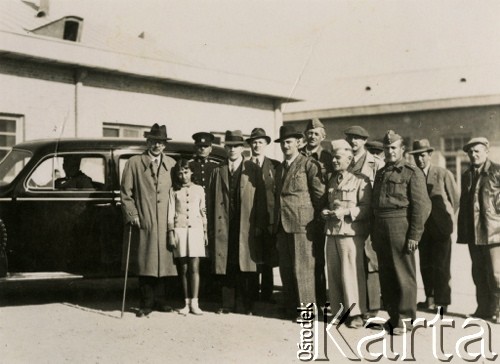 1943, Teheran, Iran.
Pracownicy administracji obozu dla Polaków ewakuowanych z ZSRR (Nr 2), wśród nich starosta Roman Dusza (w pierwszym rzędzie, 2. od prawej). [Polscy uchodźcy trafili do Iranu w 1942 wraz z nowoutworzonym Wojskiem Polskim pod dowództwem generała Władysława Andersa (w dwóch rzutach ewakuacyjnych z ZSRR w marcu i sierpniu). W sumie oprócz wojska dotarło tam 38 tysięcy Polaków, z czego ponad połowę stanowiły dzieci i młodzież. W Teheranie powstały trzy obozy dla ludności cywilnej i sierociniec; stąd kierowano Polaków do stałych osiedli w różnych rejonach świata (np. w Nowej Zelandii, Ugandzie, Meksyku)]. 
Fot. NN, zbiory Ośrodka KARTA, kolekcja Adeli Duszy przekazała Halina Guść