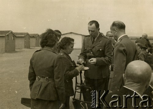 25.04.1943, Teheran, Iran.
Święta Wielkanocne w garnizonie. Płk Borucki (po środku) przyjmuje życzenia od komendant PSK (Pomocniczej Służby Kobiet) Rojanowej (po lewej). Po prawej attache wojskowy płk Szymański. [Polscy uchodźcy trafili do Iranu w 1942 wraz z nowoutworzonym Wojskiem Polskim pod dowództwem generała Władysława Andersa (w dwóch rzutach ewakuacyjnych z ZSRR w marcu i sierpniu). W sumie oprócz wojska dotarło tam 38 tysięcy Polaków, z czego ponad połowę stanowiły dzieci i młodzież. W Teheranie powstały trzy obozy dla ludności cywilnej i sierociniec; stąd kierowano Polaków do stałych osiedli w różnych rejonach świata (np. w Nowej Zelandii, Ugandzie, Meksyku)].
Fot. NN, zbiory Ośrodka KARTA, kolekcja Adeli Duszy przekazała Halina Guść