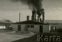 Wrzesień 1943, Teheran, Iran.
Budynek kuchenny w obozie dla Polaków ewakuowanych z ZSRR (Nr 1). [Polscy uchodźcy trafili do Iranu w 1942 wraz z nowoutworzonym Wojskiem Polskim pod dowództwem generała Władysława Andersa (w dwóch rzutach ewakuacyjnych z ZSRR w marcu i sierpniu). W sumie oprócz wojska dotarło tam 38 tysięcy Polaków, z czego ponad połowę stanowiły dzieci i młodzież. W Teheranie powstały trzy obozy dla ludności cywilnej i sierociniec; stąd kierowano Polaków do stałych osiedli w różnych rejonach świata (np. w Nowej Zelandii, Ugandzie, Meksyku)].
Fot. NN, zbiory Ośrodka KARTA, kolekcja Adeli Duszy przekazała Halina Guść