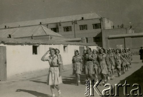 Wrzesień 1943, Teheran, Iran.
Defilada harcerska w obozie dla Polaków ewakuowanych z ZSRR (Nr 1). [Polscy uchodźcy trafili do Iranu w 1942 wraz z nowoutworzonym Wojskiem Polskim pod dowództwem generała Władysława Andersa (w dwóch rzutach ewakuacyjnych z ZSRR w marcu i sierpniu). W sumie oprócz wojska dotarło tam 38 tysięcy Polaków, z czego ponad połowę stanowiły dzieci i młodzież. W Teheranie powstały trzy obozy dla ludności cywilnej i sierociniec; stąd kierowano Polaków do stałych osiedli w różnych rejonach świata (np. w Nowej Zelandii, Ugandzie, Meksyku)].
Fot. NN, zbiory Ośrodka KARTA, kolekcja Adeli Duszy przekazała Halina Guść