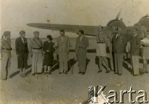 1943, Teheran, Iran. 
Grupa osób przy samolocie.[Polscy uchodźcy trafili do Iranu w 1942 wraz z nowoutworzonym Wojskiem Polskim pod dowództwem generała Władysława Andersa (w dwóch rzutach ewakuacyjnych z ZSRR w marcu i sierpniu). W sumie oprócz wojska dotarło tam 38 tysięcy Polaków, z czego ponad połowę stanowiły dzieci i młodzież. W Teheranie powstały trzy obozy dla ludności cywilnej i sierociniec; stąd kierowano Polaków do stałych osiedli w różnych rejonach świata (np. w Nowej Zelandii, Ugandzie, Meksyku)].
Fot. NN, zbiory Ośrodka KARTA, kolekcja Adeli Duszy przekazała Halina Guść