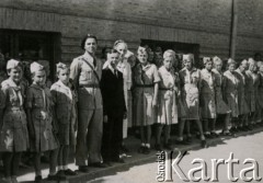 1944, Teheran, Iran.
Starosta Roman Dusza (w garniturze) z harcerzami w obozie dla Polaków ewakuowanych z ZSRR (Nr 2). [Polscy uchodźcy trafili do Iranu w 1942 wraz z nowoutworzonym Wojskiem Polskim pod dowództwem generała Władysława Andersa (w dwóch rzutach ewakuacyjnych z ZSRR w marcu i sierpniu). W sumie oprócz wojska dotarło tam 38 tysięcy Polaków, z czego ponad połowę stanowiły dzieci i młodzież. W Teheranie powstały trzy obozy dla ludności cywilnej i sierociniec; stąd kierowano Polaków do stałych osiedli w różnych rejonach świata (np. w Nowej Zelandii, Ugandzie, Meksyku)].
Fot. NN, zbiory Ośrodka KARTA, kolekcja Adeli Duszy przekazała Halina Guść