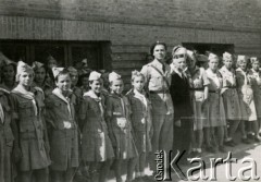 1944, Teheran, Iran.
Starosta Roman Dusza (w garniturze) z harcerzami w obozie dla Polaków ewakuowanych z ZSRR (Nr 2). [Polscy uchodźcy trafili do Iranu w 1942 wraz z nowoutworzonym Wojskiem Polskim pod dowództwem generała Władysława Andersa (w dwóch rzutach ewakuacyjnych z ZSRR w marcu i sierpniu). W sumie oprócz wojska dotarło tam 38 tysięcy Polaków, z czego ponad połowę stanowiły dzieci i młodzież. W Teheranie powstały trzy obozy dla ludności cywilnej i sierociniec; stąd kierowano Polaków do stałych osiedli w różnych rejonach świata (np. w Nowej Zelandii, Ugandzie, Meksyku)].
Fot. NN, zbiory Ośrodka KARTA, kolekcja Adeli Duszy przekazała Halina Guść