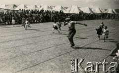 31.12.1944, Karaczi, Indie.
Święto sportowe, najmłodsi uczestnicy w czasie biegu. [Polscy uchodźcy w 1942 trafili do Iran.u wraz z nowoutworzonym Wojskiem Polskim pod dowództwem generała Władysława Andersa (w dwóch rzutach ewakuacyjnych z ZSRR w marcu i sierpniu). W sumie oprócz wojska dotarło tam 38 tysięcy Polaków, z czego ponad połowę stanowiły dzieci i młodzież. Około 10 tysięcy z nich trafiła potem do Indii, m.in. do dwóch obozów przejściowych w Karaczi]
Fot. NN, zbiory Ośrodka KARTA, kolekcja Adeli Duszy przekazała Halina Guść