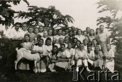 1946, Valivade, Indie.
Uczestnicy kursu maszynopisania w obozie dla polskich uchodźców. W pierwszym rzędzie siedzi Starosta Roman Dusza. [Osiedle stałe w Valivade zostało wybudowane wiosną 1943 dla polskich uchodźców (głównie kobiet z dziećmi), którzy trafili do Iran.u wraz z nowoutworzonym Wojskiem Polskim pod dowództwem generała Władysława Andersa. Posiadało m.in. polską administrację samorządową, kościół, teatr, sklepy, cukiernie, szpitale, straż pożarną. W latach 1943–1947 przez osiedle przeszło około pięciu tysięcy Polaków].
Fot. NN, zbiory Ośrodka KARTA, kolekcja Adeli Duszy przekazała Halina Guść