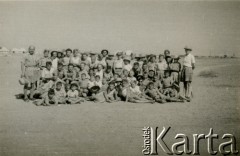 Marzec 1945, Karaczi, Indie.
Grupa dzieci i opiekunów w obozie dla polskich uchodźców. [Polscy uchodźcy w 1942 trafili do Iran.u wraz z nowoutworzonym Wojskiem Polskim pod dowództwem generała Władysława Andersa (w dwóch rzutach ewakuacyjnych z ZSRR w marcu i sierpniu). W sumie oprócz wojska dotarło tam 38 tysięcy Polaków, z czego ponad połowę stanowiły dzieci i młodzież. Około 10 tysięcy z nich trafiła potem do Indii, m.in. do dwóch obozów przejściowych w Karaczi]
Fot. NN, zbiory Ośrodka KARTA, kolekcja Adeli Duszy przekazała Halina Guść