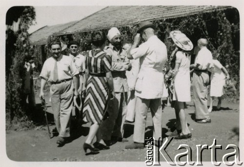 1946, Valivade, Indie.
Polscy uchodźcy w rozmowie z Hindusem. [Osiedle stałe w Valivade zostało wybudowane wiosną 1943 dla polskich uchodźców (głównie kobiet z dziećmi), którzy trafili do Iran.u wraz z nowoutworzonym Wojskiem Polskim pod dowództwem generała Władysława Andersa. Posiadało m.in. polską administrację samorządową, kościół, teatr, sklepy, cukiernie, szpitale, straż pożarną. W latach 1943–1947 przez osiedle przeszło około pięciu tysięcy Polaków].
Fot. NN, zbiory Ośrodka KARTA, kolekcja Adeli Duszy przekazała Halina Guść