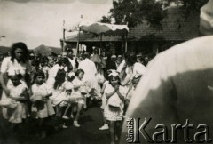 20.06.1946, Valivade, Indie.
Uroczysta procesja Bożego Ciała. [Osiedle stałe w Valivade zostało wybudowane wiosną 1943 dla polskich uchodźców (głównie kobiet z dziećmi), którzy trafili do Iran.u wraz z nowoutworzonym Wojskiem Polskim pod dowództwem generała Władysława Andersa. Posiadało m.in. polską administrację samorządową, kościół, teatr, sklepy, cukiernie, szpitale, straż pożarną. W latach 1943–1947 przez osiedle przeszło około pięciu tysięcy Polaków].
Fot. NN, zbiory Ośrodka KARTA, kolekcja Adeli Duszy przekazała Halina Guść