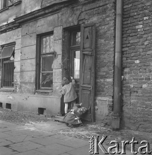 Lata 50., Warszawa, Polska.
Dzieci przy drzwiach kamienicy przy ul. Jagiellońskiej w pobliżu ul. Kępnej 
Fot. Irena Jarosińska, zbiory Ośrodka KARTA