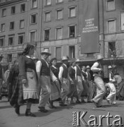 Lata 50., Warszawa, Polska.
Pochód pierwszomajowy w Alejach Jerozolimskich - uczestnicy w strojach ludowych. Na budynku zawieszono sztandar z hasłem: 