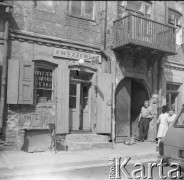 1968, Zamość, woj. lubelskie, Polska.
Mężczyzna stoi w bramie kamienicy. Na parterze znajdują się zakłady usługowe. 
Fot. Irena Jarosińska, zbiory Ośrodka KARTA