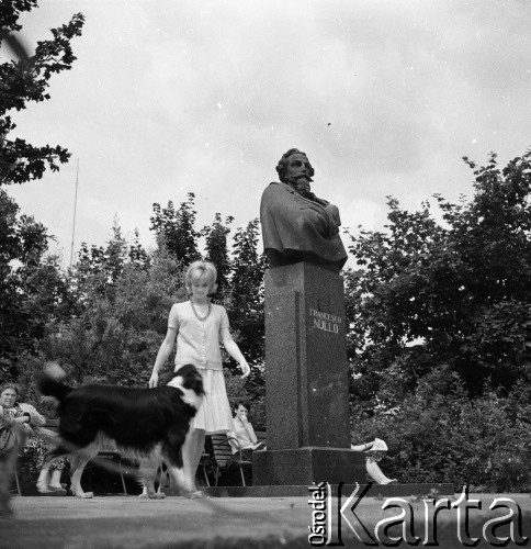 Lata 60., Warszawa, Polska.
Żona aktora i piosenkarza Jerzego Michotka przy pomniku Francesca Nulla u zbiegu ulic Frascati, Senackiej i Nulla.
Fot. Irena Jarosińska, zbiory Ośrodka KARTA
