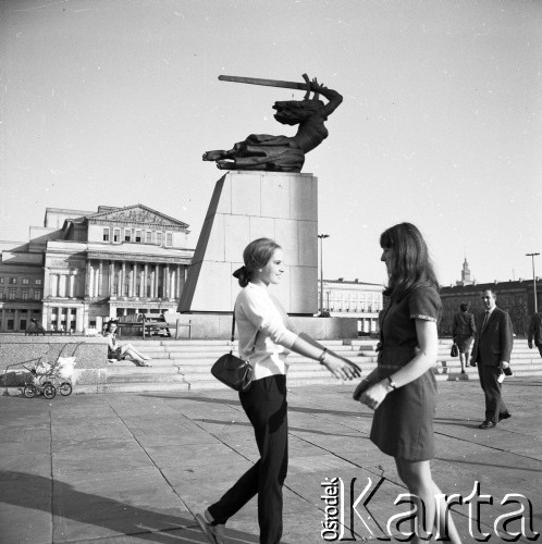 Lata 60. lub 70., Warszawa, Polska.
Dorota Waligórska (z lewej) i Hanna Roguska - koleżanki Marka Jarosińskiego - syna fotografki Ireny Jarosińskiej - na Placu Teatralnym przy pomniku Nike. W tle Teatr Wielki.
Fot. Irena Jarosińska, zbiory Ośrodka KARTA


