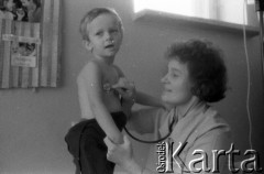 Lata 60. lub 70., Polska.
Lekarka bada chłopca.
Fot. Irena Jarosińska, zbiory Ośrodka KARTA