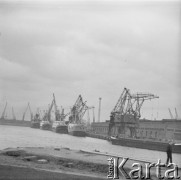 lata 60-te, Szczecin, Polska.
Port Szczecin. Chłopiec spaceruje na nabrzeżu, w tle widać okręty i żurawie portowe.
Fot. Irena Jarosinska, zbiory Oorodka KARTA.