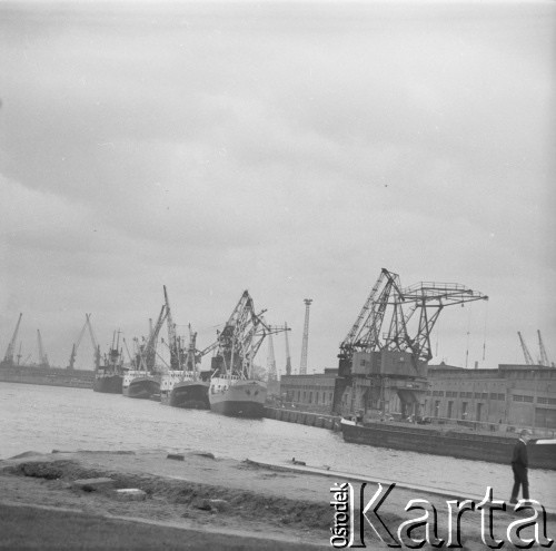 lata 60-te, Szczecin, Polska.
Port Szczecin. Chłopiec spaceruje na nabrzeżu, w tle widać okręty i żurawie portowe.
Fot. Irena Jarosinska, zbiory Oorodka KARTA.