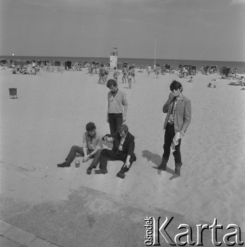 22-25.08.1968, Sopot, Polska.
Międzynarodowy Festiwal Piosenki w Sopocie. Członkowie zespołu Czerwone Gitary na plaży. Na piasku od lewej siedzą Bernard Dornowski i Jerzy Skrzypczyk, za nimi stoi Seweryn Krajewski, a obok niego Krzysztof Klenczon.
Fot. Irena Jarosińska, zbiory Ośrodka KARTA

