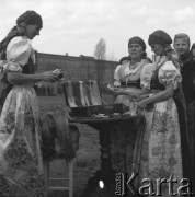 Lata 50., Katowice, Polska.
Kobiety w śląskich strojach ludowych przy stoisku z dewocjonaliami przed kościołem Chrystusa Króla.
Fot. Irena Jarosińska, zbiory Ośrodka KARTA