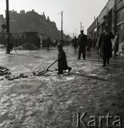 lata 50-te, Warszawa, Polska
Aleje Jerozolimskie (w głębi widać skrzyżowanie z ul.  Marszałkowską) - dziecko odśnieża chodnik.
Fot. Irena Jarosińska, zbiory Ośrodka KARTA