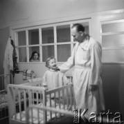 Lata 50., Leszno, Polska.
Wnętrze sali szpitalnej oddziału dziecięcego. W trakcie obchodu lekarskiego.
Fot. Irena Jarosińska, zbiory Ośrodka KARTA