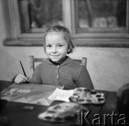 Lata 50., Leszno, Polska.
Portret dziewczynki podczas zajęć plastycznych. Na stole farby akwarelowe.
Fot. Irena Jarosińska, zbiory Ośrodka KARTA