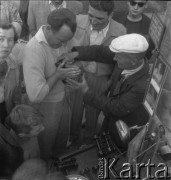 Lata 50., Warszawa, Polska.
Migawki spod Uniwersytetu. Mężczyzna sprzedający urządzenie do ćwiczenia.
Fot. Irena Jarosińska, zbiory Ośrodka KARTA