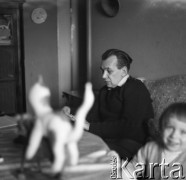 Lata 60., Polska.
Mężczyzna  z dzieckiem przy stole. Na pierwszym planie na stole widoczne dzięcięce zabawki.
Fot. Irena Jarosińska, zbiory Ośrodka KARTA