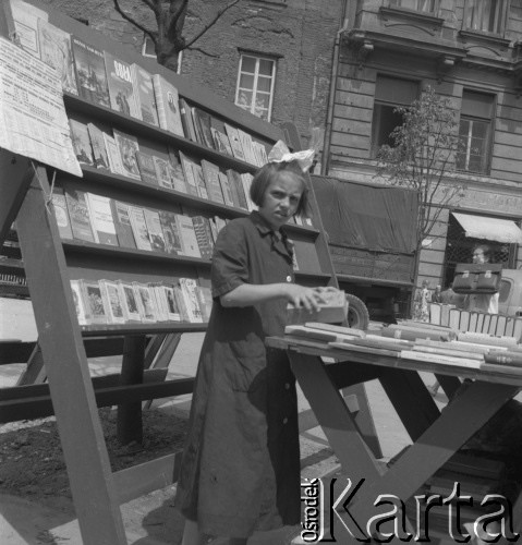 Lata 50., Warszawa, Polska.
Dziewczynka sprzedaje książki przy Centralnym Domu Towarowym.
Fot. Irena Jarosińska, zbiory Ośrodka KARTA