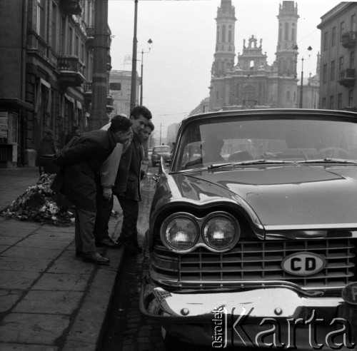 Lata 60., Warszawa, Polska.
Aktor Ludwik Halicz (trzeci) na ulicy Marszałkowskiej w pobliżu Placu Zbawiciela. W tle kościół Najświętszego Zbawiciela.
Fot. Irena Jarosińska, zbiory Ośrodka KARTA