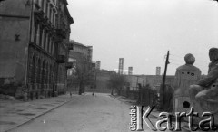 Lata 50. lub 60., Warszawa, Polska.
Ulica Aleksandra Fredry – widok w kierunku północno-wschodnim. Rzeźby Adama Mickiewicza i Mikołaja Kopernika ( z prawej). Od lewej kolejno budynki na ulicy Aleksandra Fredry 8 i 6, dalej Teatr Wielki i blok przy ulicy Moliera 2/4/6.
Fot. NN, kolekcja Ireny Jarosińskiej, zbiory Ośrodka KARTA