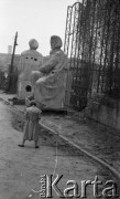 Lata 50. lub 60., Warszawa, Polska.
Fotografka Irena Jarosińska na ulicy Aleksandra Fredry fotografuje rzeźby Adama Mickiewicza i Mikołaja Kopernika.
Fot. NN, kolekcja Ireny Jarosińskiej, zbiory Ośrodka KARTA